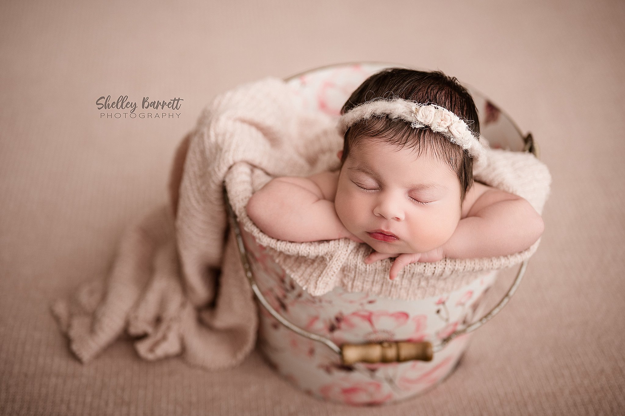 Sleeping newborn photographed in a bucket by a Springville newborn photographer in Trussville, Alabama