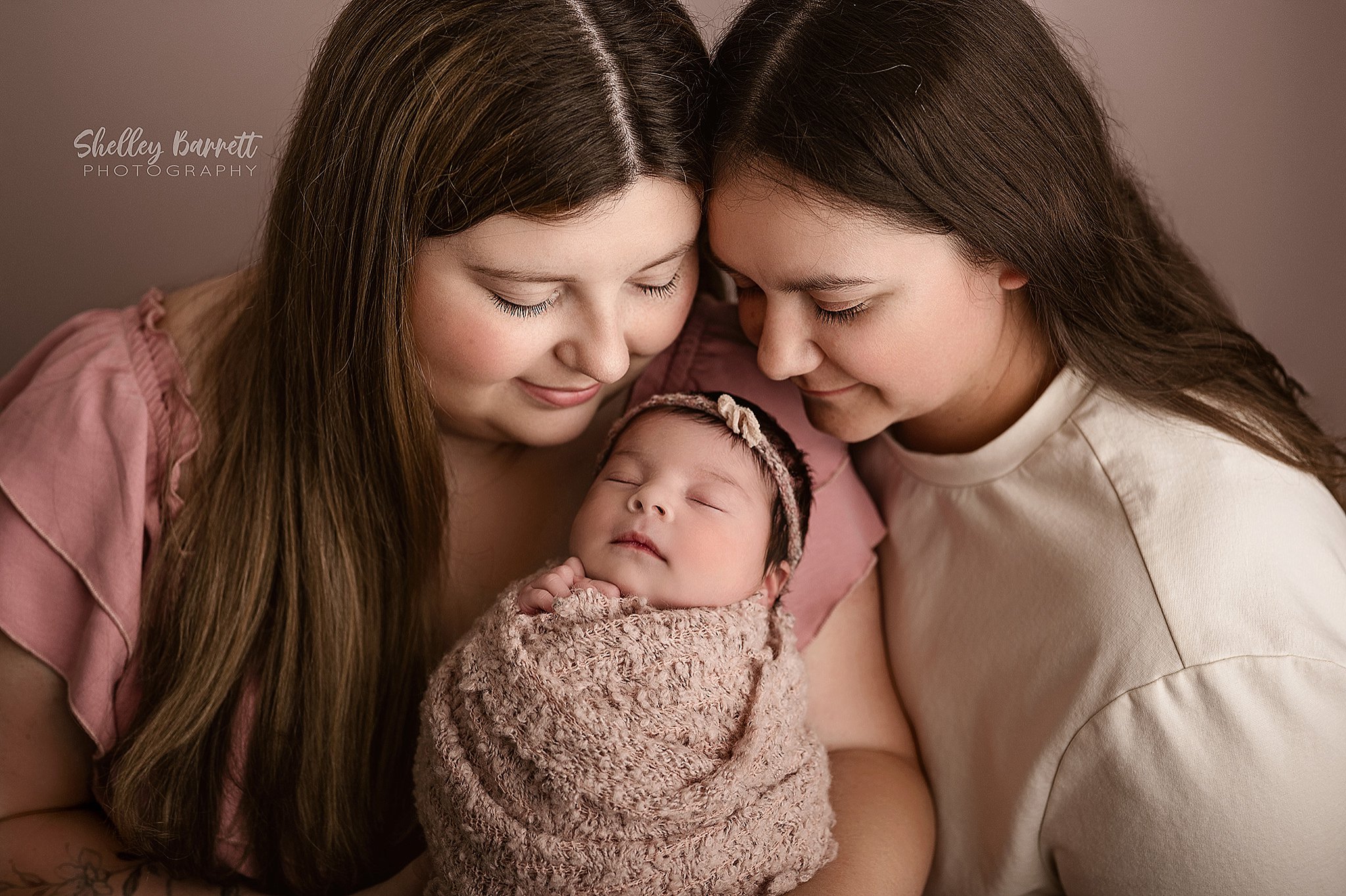 Mothers holding newborn during a newborn photography session near Trussville, Alabama