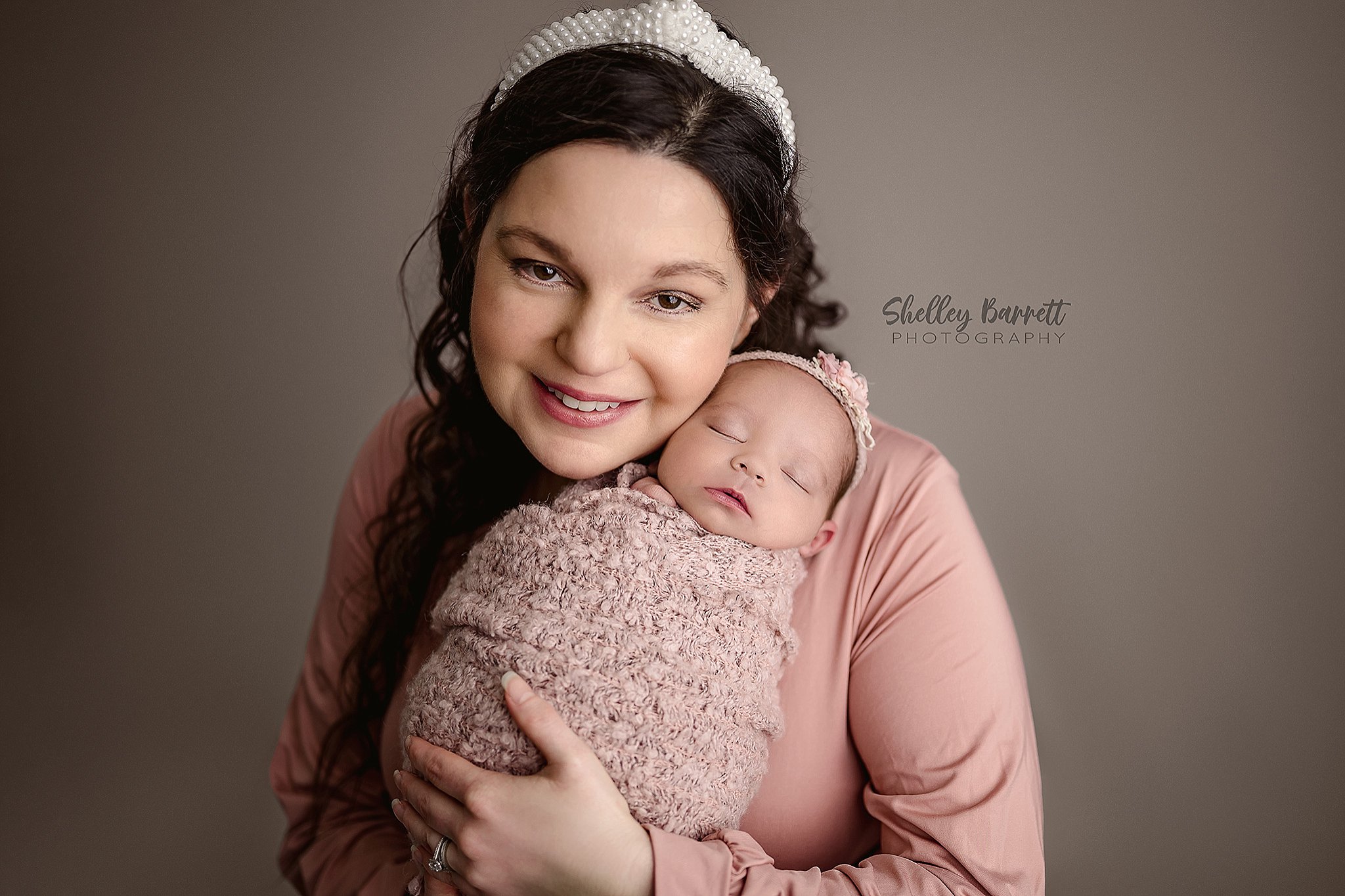 Mother holding newborn baby during professional newborn session in Alabama