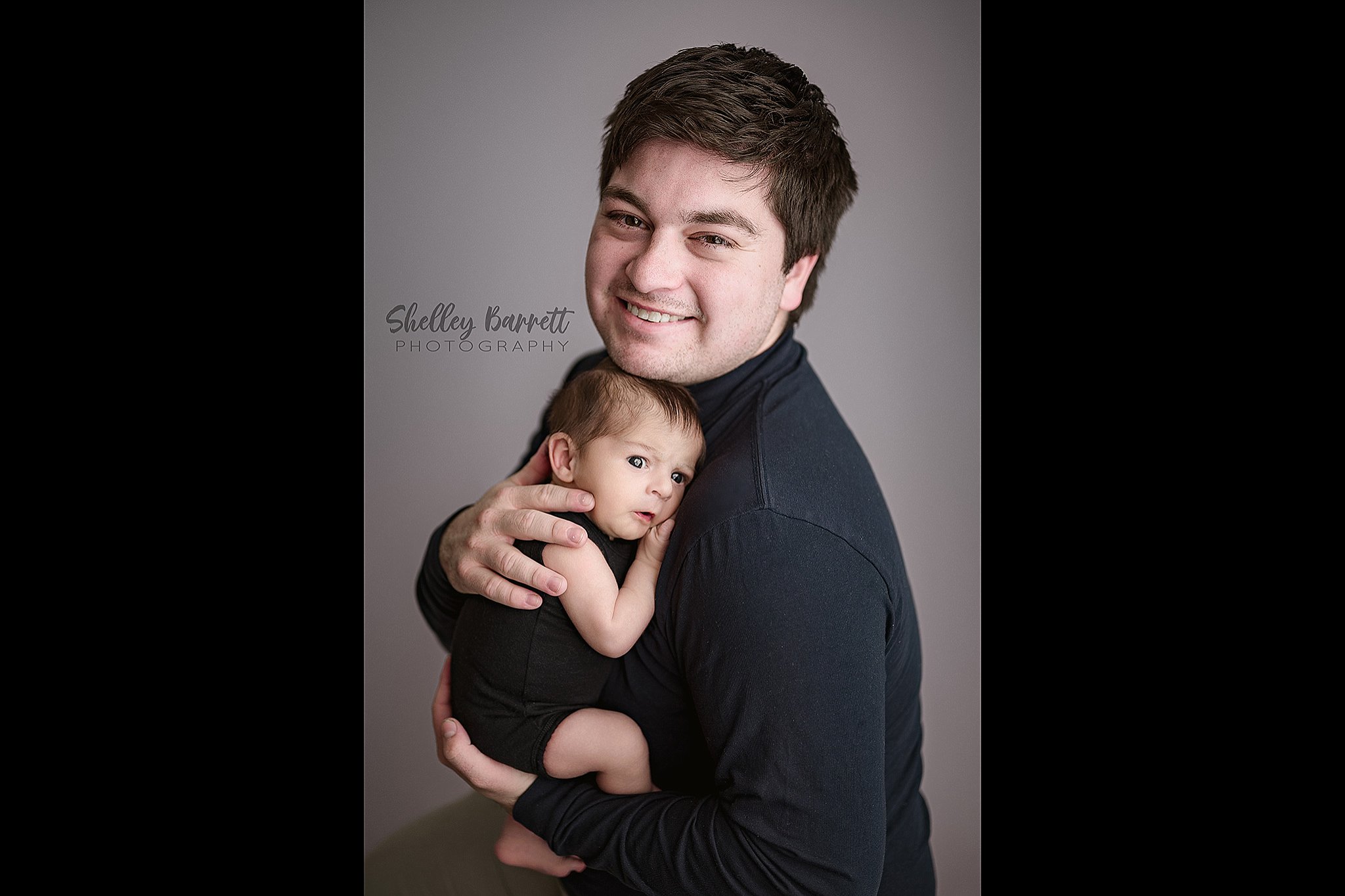 Father holding his newborn baby during a Birmingham newborn photography session