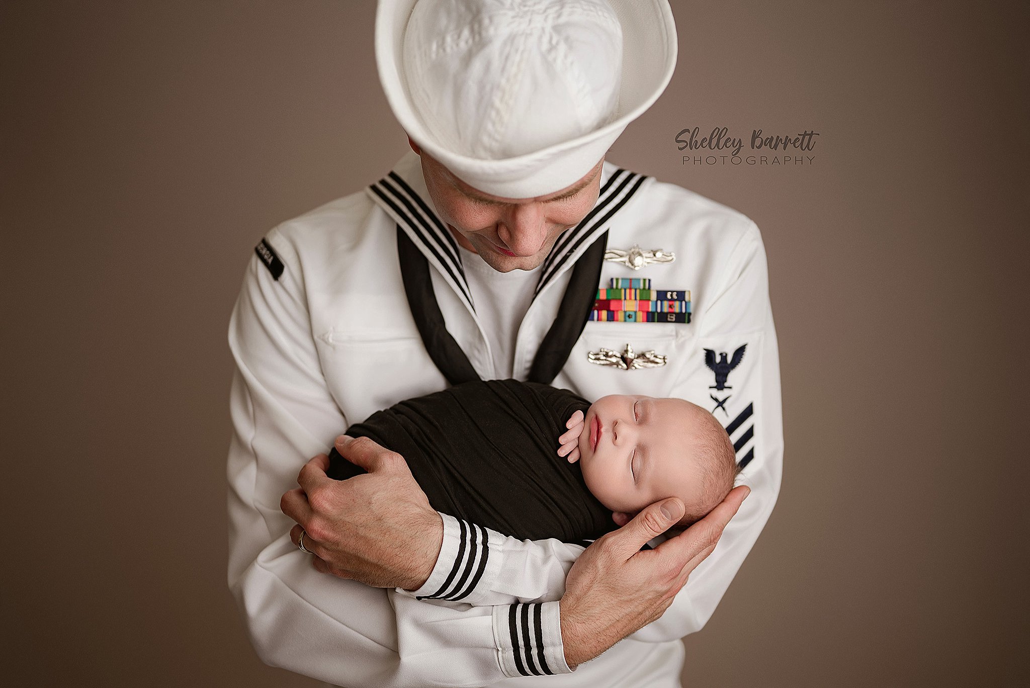 USA Sailor in uniform Father cuddling his newborn son during a Birmingham newborn photography session
