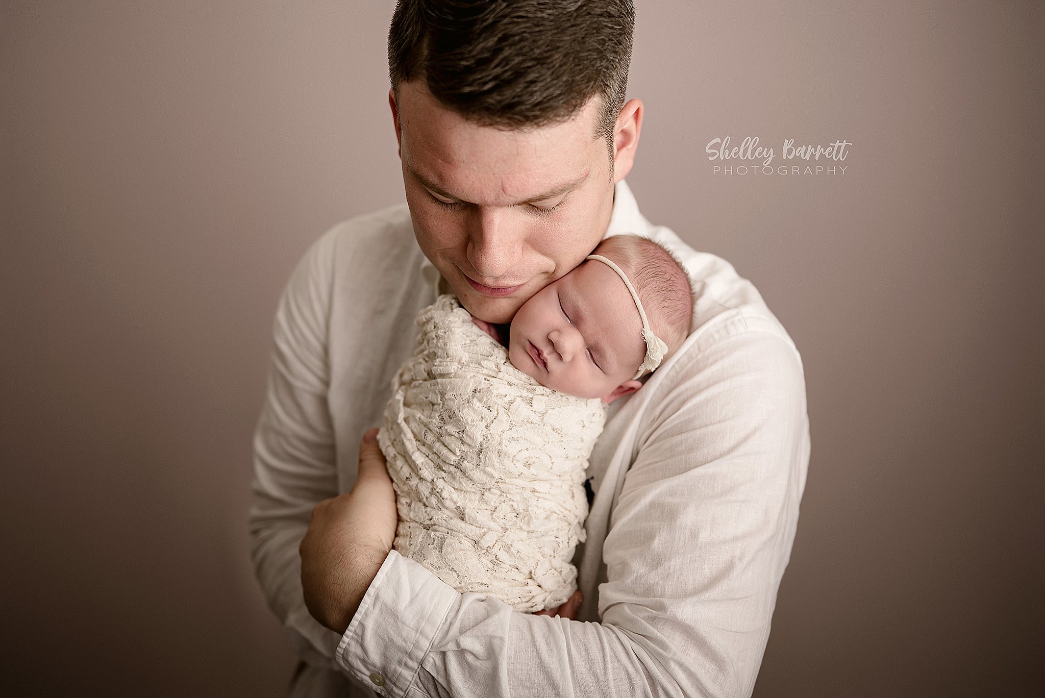 Dad gently holding his baby during a Springville Alabama newborn photography session