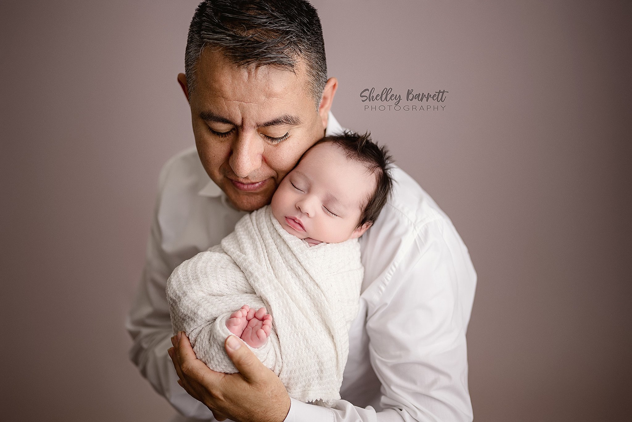 Dad showing affection to his newborn during a professional newborn portrait session