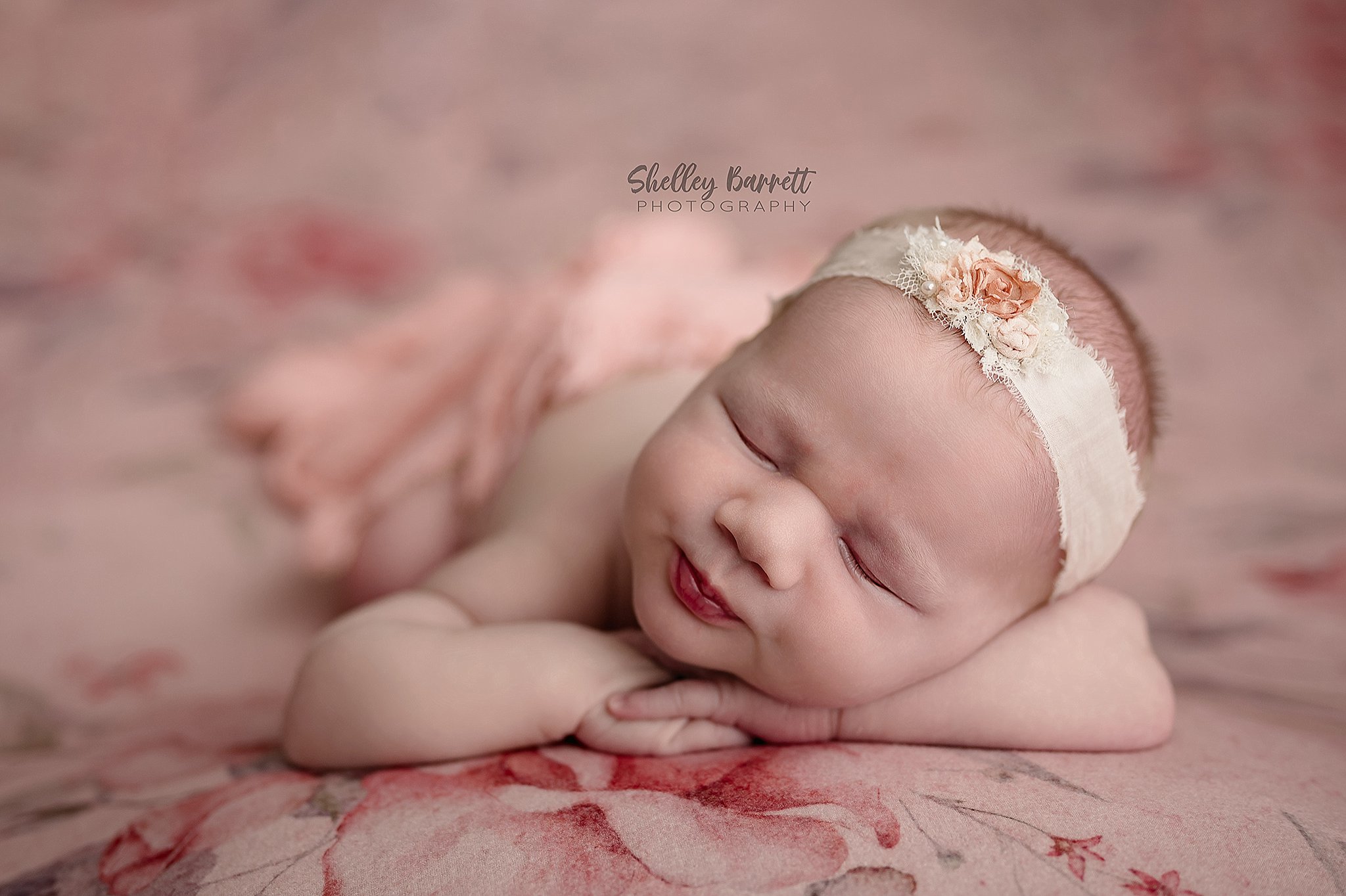 Tiny newborn baby girl sleeping unwrapped with her hands tucked under her chin during a timeless Birmingham newborn photography session.
